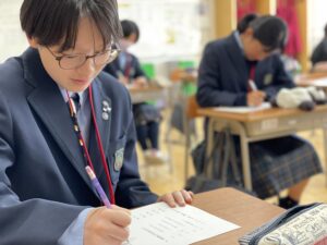 本日(4/19(金))2限は「日本の伝統文化」の授業です。
中学生は3年間で「マナー」「茶道」「短歌俳句」「華道」「書の作法」「着付け」を学んでいきます。
本日は初回授業です。１年生は「マナー」を学びました。座席からの立ち方や座り方、礼の角度などを学びました。
２年生は「短歌俳句」を学びました。俳句の基本や江戸時代の三大俳人、季語を学びました。
３年生は「着付け」を学びました。浴衣の畳み方や、帯の結び方など着付け方法を学びました。